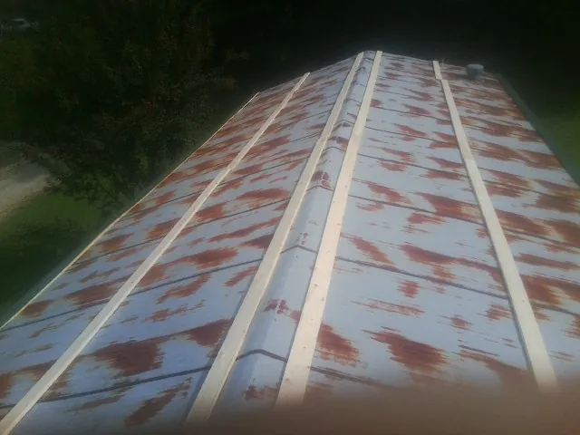 Rusted metal roof panels with new wood purlins before replacement — Storm Damage Roof Repair in Glen Allen by Roofing Brothers