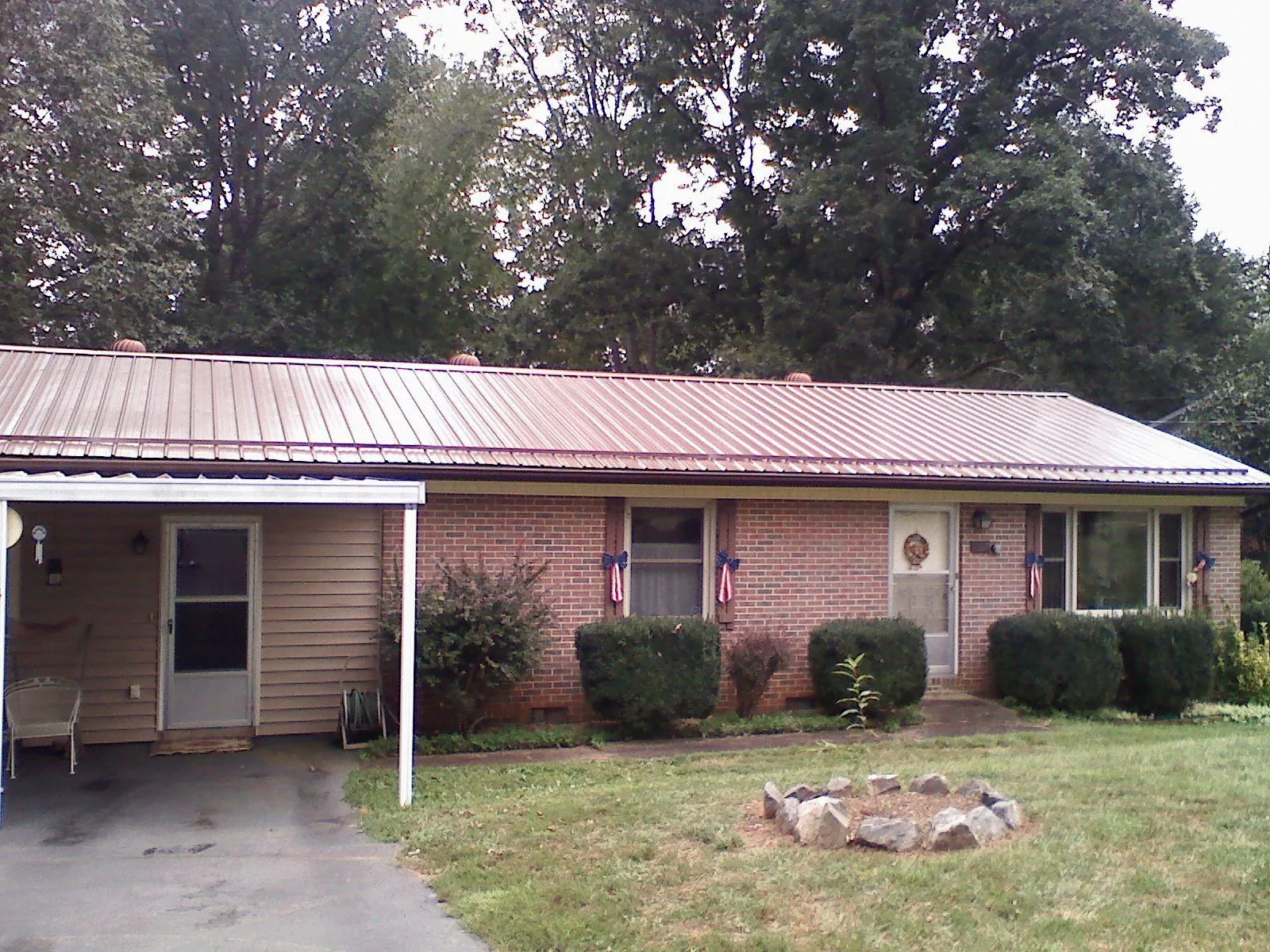 Bronze metal roof and carport on a brick ranch home — Roof Repair work by our crew in Glen Allen